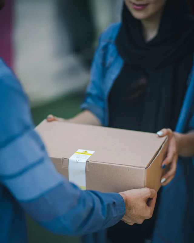 Etiketli bir kargo kolisi elden ele teslim ediliyor